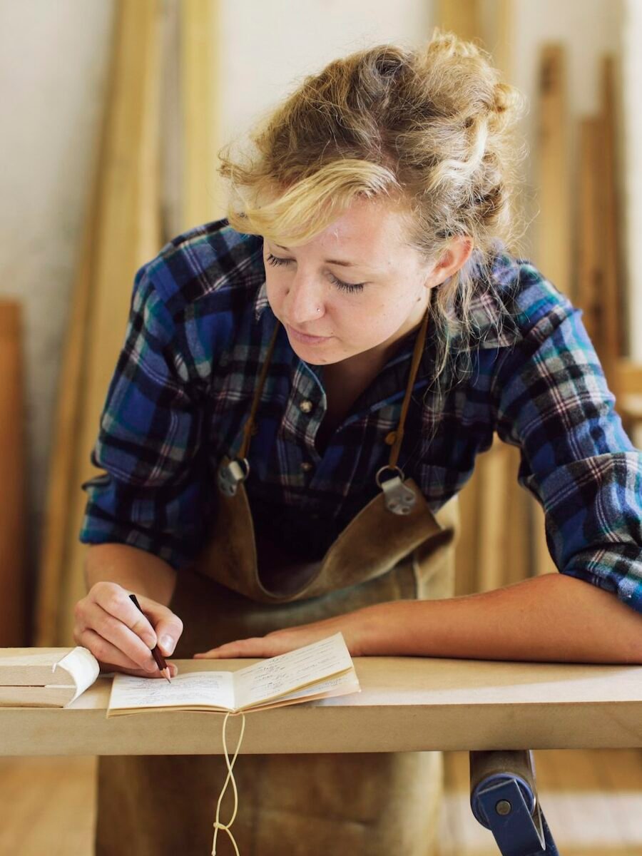 Young craftswoman making notes in pipe organ workshop